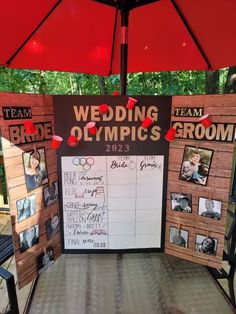 a table with a sign on it that says wedding olympics 2012 and has pictures pinned to it