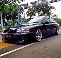 a black car is parked on the side of the road