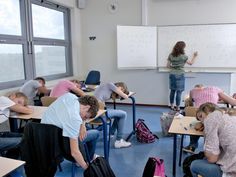 a group of people sitting at desks in a classroom