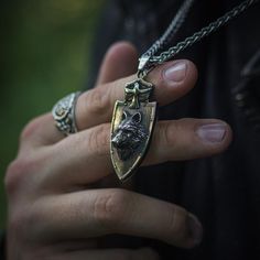 The wolf and the raven were powerful symbols of the warrior spirit. The Nordic Wolf and Raven Pendant, a striking piece of Viking jewelry, combines these two legendary creatures in a testament to strength and wisdom. The wolf, with its piercing gaze, represents the fearless heart of the warrior, while the raven, perched on the wolf's back, embodies the keen insight and knowledge that guide the warrior's path. Wear this Viking necklace as a reminder of your own inner strength and wisdom, a talism Silver Viking Jewelry For Fantasy Events, Bronze Viking Jewelry Collectible, Medieval Black Jewelry For Fantasy Events, Viking Style Silver Wolf Design Jewelry, Viking Style Silver Jewelry With Wolf Design, Gothic Engraved Jewelry For Larp, Viking Style Wolf Design Jewelry Gift, Black Warrior Style Jewelry As Gift, Viking Style Engraved Jewelry For Larp