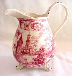 a red and white pitcher sitting on top of a table