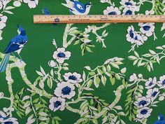 blue birds and white flowers on green background with ruler