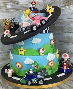 a three tiered cake decorated with mario kart and friends