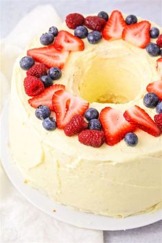 a white cake with berries and blueberries on top