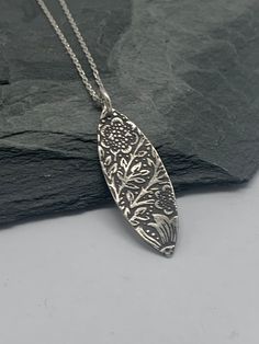 This lovely oval floral daisy necklace has been entirely handmade using .999 fine silver. It has been cut from fine silver precious metal clay, textured, fired and oxidized. The pendant hangs from a sterling silver diamond cut cable chain. This fine silver long oval pendant features an embossed daisy floral textured pattern. Pendant size: approximately 1 1/4 x 1/2 inches Chain length: adjustable at 16 and 18 inches can also be customized to whatever length needed The necklace is sent in a gift b Layered Necklaces Boho, Moon Necklace Silver, Silver Bar Necklace, Layered Necklaces Silver, Oval Necklace, Daisy Necklace, Precious Metal Clay, Charm Necklace Silver, Pretty Necklaces