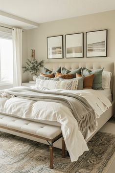 a large bed sitting in a bedroom next to two pictures on the wall above it