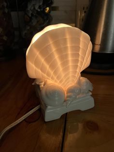 a shell shaped lamp sitting on top of a wooden table