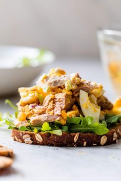 a sandwich with meat, lettuce and cheese on it next to crackers