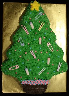 a cake shaped like a christmas tree with scissors and other items on it's side