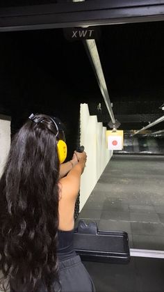 a woman with headphones is shooting an object