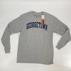 Condition: New With Tags Size: Multiple Sizes Color: Grey T-Shirt With A Navy Blue Graphic Retail: $39.98 45 Available Super Soft 90% Cotton / 10% Poly Long Sleeve Tee Shirt From The Victory. 100% Authentic Ncaa Apparel With Classic Georgetown Lettering On Chest. Perfect Basketball, Hoyas, Ncaa Basketball, Around Campus Long Sleeve T-Shirt. Athletic Heather Cotton Tops For Fall, Casual Gray T-shirt For College, College Heather Grey Tops With Letter Print, Heather Grey Letter Print Top For College, Heather Grey Cotton Tops With Letter Print, Casual Pre-shrunk Athletic Heather Top, Casual Athletic Heather Pre-shrunk Top, Sporty Heather Grey Tops For College, Casual Heather Grey Top With Text Print