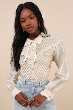 Timeless romance is the essence of the Sister Jane Pony Cream Sheer Pintuck Lace Long Sleeve Button-Up Top! Sheer, lightweight woven fabric shapes this vintage-inspired blouse that has long sleeves with rhinestone button cuffs and a collared neckline with an attached ribbon tie. Bodice boasts an angular design of pintuck pleats and a functional button placket with sparkly rhinestone buttons. Crochet lace trim throughout completes this sweetly chic look. Fit: This garment fits true to size. Lengt Lace Long Sleeve Top Outfit, Vintage Long Sleeve Top With Lace Collar, Cream Long Sleeve Top With Lace Collar, Feminine Lace Button-up Top, Lace Collar Shirt, Vintage Cream Button-up Blouse, Pintuck Pleats, White Sheer Button-up Blouse, Womens Lace Tops