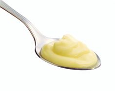 a spoon full of mayonnaise on a white background