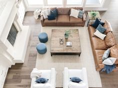 an overhead view of a living room with couches, tables and pillows on the floor