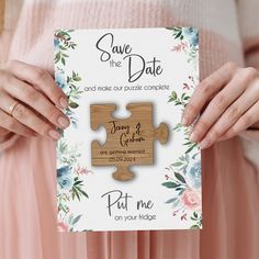 a person holding a puzzle piece with the words save the date printed on it in front of them