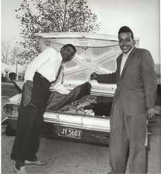 two men standing next to an open trunk