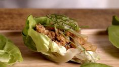 lettuce wraps with meat and herbs on a cutting board