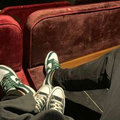 two people are sitting on the train with their feet propped against each other's legs