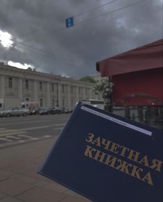 a blue book sitting on the side of a road next to a tall white building