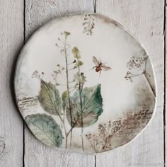 a plate with some plants on it sitting on a wooden table next to a wall