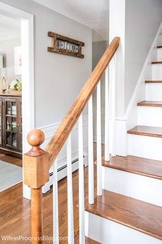 a wooden banister sitting on top of a wooden floor next to a stair case