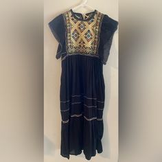 This Is Such A Beautiful And Unique Dress, Very Well Made. I Can Tell It Was Made With Love So This Will Fit Someone Who Wears A Small Or A Medium. If Your Bra Size Is Bigger Than A 36b This Will Probably Not Fit You. To Be Honest, It Looks Brand New. No Tags To Indicate Size But I Just Tried It On (See Video) And I'm A Medium Feels Like Linen To Me And There's That Beautiful Bodice Embroidery. The Back Closes With A Tassels. I'm 5'3" And It Falls To My Ankles Black Folk Embroidered Summer Dress, Black Folk Style Summer Dress, Black Embroidered Dress With Geometric Patterns For Spring, Casual Embroidered Dress For Festive Occasions, Black Bohemian Embroidered Dress With Geometric Pattern, Black Embroidered Bohemian Dress, Fitted Black Bohemian Embroidered Dress, Black Fitted Bohemian Embroidered Dress, Black Folk Dress With Floral Embroidery