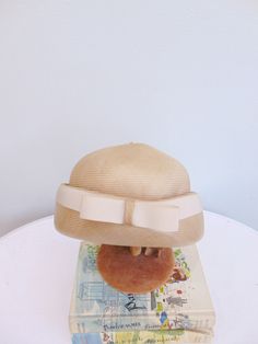 "Beautiful 60's fine weave beige dome style hat. Wide upturned brim with cream grosgrain ribbon trim. Made in England for \"Alexander's\". Measurements: 21\" Circumference inside 6\" height to top of button 29\" circumference outside brim Brand/Maker: Made in England for Alexander's Condition: Excellent! *Please feel free to message me with any additional questions * { Instagram. Hamptonsvintagemarket } { Facebook. @HamptonsVintageMarket }" Beige Cloche Hat With Short Brim For Kentucky Derby, Beige Cloche Hat With Curved Brim For Church, Beige Short Brim Cloche Hat For Kentucky Derby, Beige Curved Brim Cloche Hat For Church, Cream Brimmed Hat For Church, Beige Brimmed Cloche Hat For Church, White Vintage Boater Hat With Short Brim, Vintage Beige Cloche Hat For Spring, Beige Cloche Straw Hat For Kentucky Derby