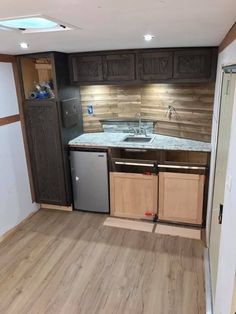 an empty kitchen with wooden cabinets and stainless steel appliances in the middle of the room