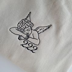 an embroidered angel on a white t - shirt with the word 999 printed on it