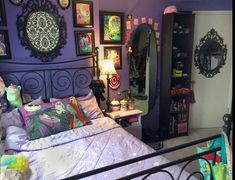 a bedroom with purple walls and pictures on the wall