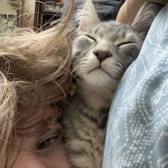 a woman holding a cat up to her face