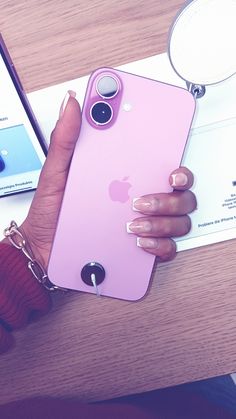 a woman's hand holding an iphone case on top of a table next to her phone