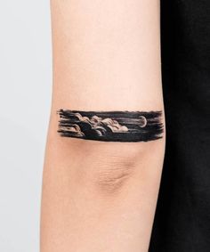 a woman's arm with a black and white tattoo design on the left side of her arm