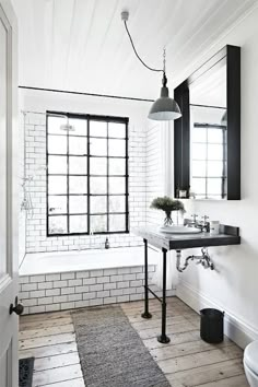 a bathroom with white walls and wooden floors