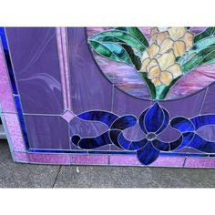 a purple stained glass door with flowers on it