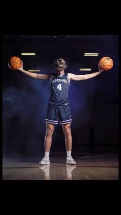 a person holding a basketball on top of a wooden floor in front of a black background