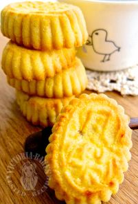 three cookies stacked on top of each other next to a cup of coffee and spoon