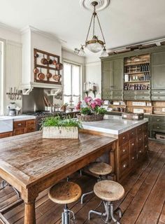 an old fashioned kitchen with wooden floors and green cabinets