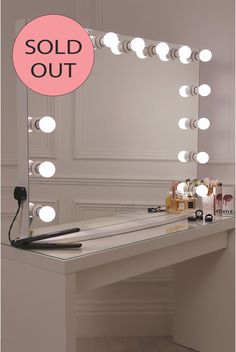 a vanity mirror with lights on top of it