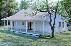 a small white house sitting on top of a lush green field next to a tree