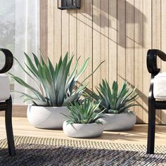 two white planters sitting on top of a wooden deck