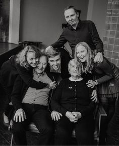 a group of people sitting next to each other posing for a black and white photo