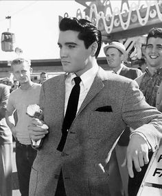 black and white photograph of man in suit holding ice cream cone with other men standing around him