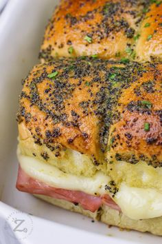 a close up of a sandwich in a white dish with black stuff on it's crust