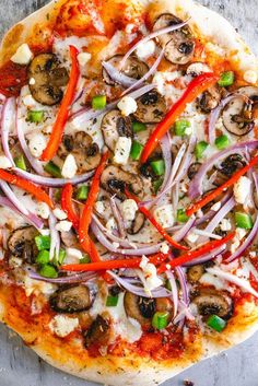 a pizza topped with mushrooms, peppers and onions