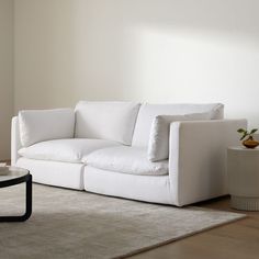 a white couch sitting on top of a rug in a living room