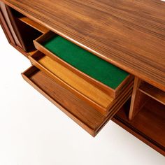 a wooden desk with green felt in the drawer