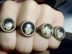 three finger rings with the faces of elvis presley and paul jackson on them are shown in front of a person's hand