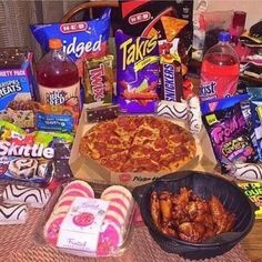 a table topped with lots of food and drinks next to bags of candy, snacks, and candies