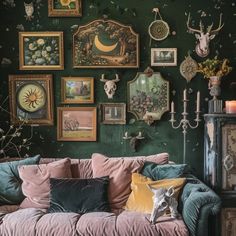 a living room with green walls and pictures on the wall, including deer head heads